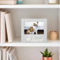 Dog photo in a frame on a shelf that reads Forever in My Heart, surrounded by books and a green plant.