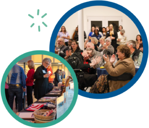 People at a community event, browsing tables and applauding a speech in a meeting hall.