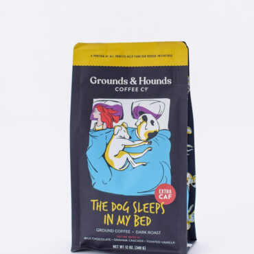 Grounds & Hounds Coffee Co. dark roast bag, The Dog Sleeps in My Bed, extra caf with dog and person illustration.