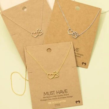 Gold and silver necklaces with heart and paw pendant on display cards, perfect for pet lovers.