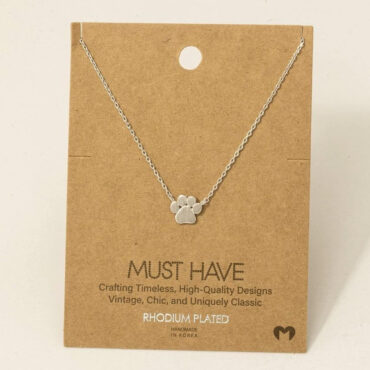 Elegant rhodium-plated necklace with paw pendant, displayed on a brown card. Perfect for pet lovers.