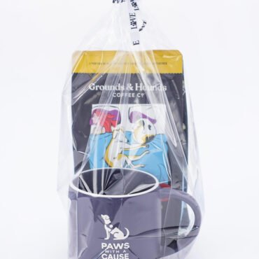 Gift set with “Paws with a Cause” mug and Grounds & Hounds coffee, wrapped in clear plastic with a ribbon.