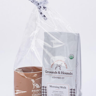 Gift set with Grounds & Hounds coffee and a mug, wrapped with a paw-print bow. Perfect for dog lovers and coffee enthusiasts.