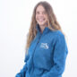 Smiling person in a blue Paws With A Cause jacket sitting casually against a white background.