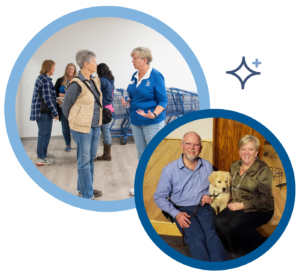 People engaging at a community event, with a couple and a dog seated together, symbolizing connection and companionship.