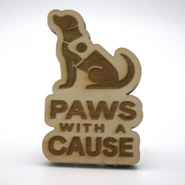 Wooden dog cutout with Paws With A Cause text, symbolizing support for pet-related initiatives.