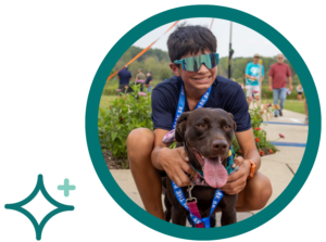 Boy in sunglasses with dog pose happily after a 5K race on a sunny day at the park.