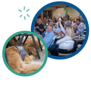 Auction event with a crowd and a visiting paws dog resting under a table, enhancing accessibility and engagement.